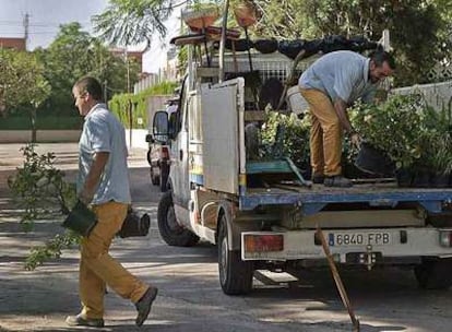 Unos operarios trasladan material de jardinería en el colegio Sanchis Yago para que todo esté a punto para la visita del presidente de la Generalitat.