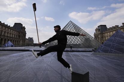 JR posa en el patio del Louvre junto a la pirámide de cristal diseñada por el arquitecto Leoh Ming Pei, en París, por su 30 aniversario.