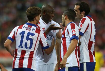 Stephane Mbia discute con tres jugadores del Atlético de Madrid.