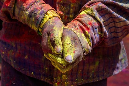 Detalle de las manos un joven indio preparado para lanzar polvo amarillo durante el festival de Jaisalmer, India.