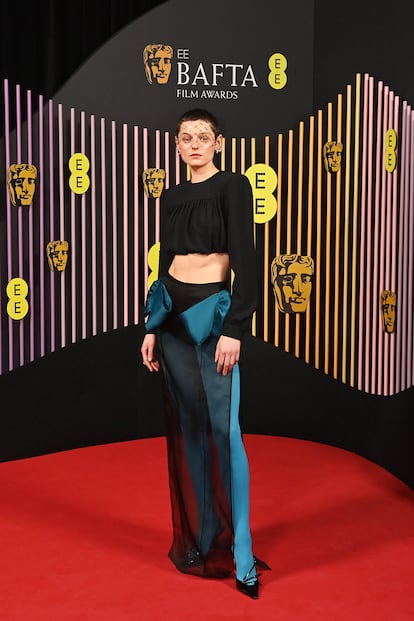 Emma Corrin optó por algo atrevido en los BAFTA de 2024. Apareció en la alfombra roja con medias de color azul brillante, una falda transparente y un top corto que dejaba al descubierto sus abdominales, cortesía de Miu Miu.