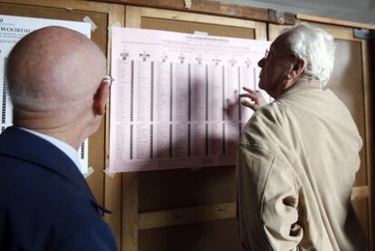 Un votante mira las listas electorales en un colegio de Berchem