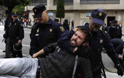 La Policía ha desalojado este martes a las seis personas que pasaron la noche de guardia dentro del Centro Social Okupado y Autogestionado (CSOA) La Madreña, en Oviedo. La actuación policial tuvo como réplica una sentada de concentración de decenas de personas en solidaridad con el colectivo en la céntrica calle General Elorza, que cortó el tráfico durante unos minutos. En la imagen, agentes de la policía desalojan una calle en Oviedo.