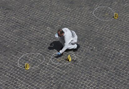 Un policía forense recoge las pruebas del tiroteo en la puerta del Quirinale.