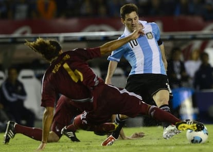 Messi conduce el bal&oacute;n ante jugadores venezolanos 