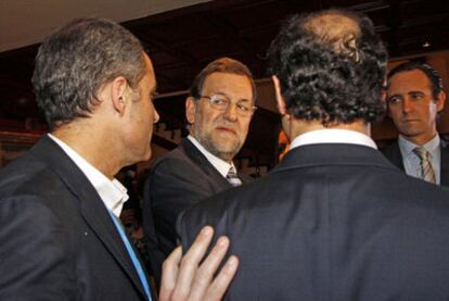 Mariano Rajoy mira a Francisco Camps (a la izquierda), durante la convención celebrada ayer en Mallorca.