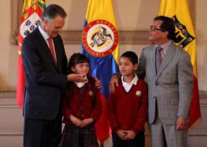 El presidente portugués, Aníbal Cavaco Silva (i), participa en un acto en donde entrega enciclopedias a niños de la localidad de Ciudad de Bolívar, junto al Alcalde Mayor de Bogotá, Gustavo Petro (d), este 17 de abril, en Bogotá (Colombia).