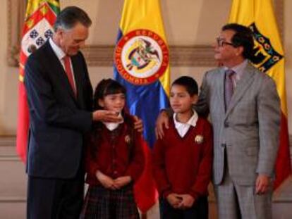 El presidente portugués, Aníbal Cavaco Silva (i), participa en un acto en donde entrega enciclopedias a niños de la localidad de Ciudad de Bolívar, junto al Alcalde Mayor de Bogotá, Gustavo Petro (d), este 17 de abril, en Bogotá (Colombia).