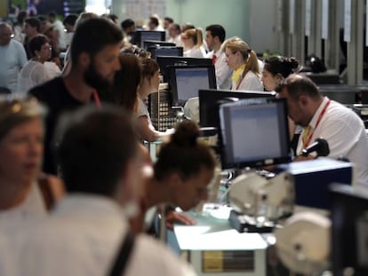 Personal de facturaci&oacute;n de Vueling atiende a los viajeros en el Aeropuerto de El Prat.