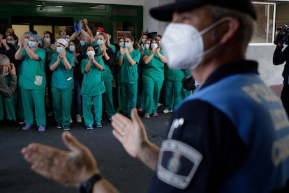 Varios sanitarios y miembros de la Policía Local aplauden a las puertas del Hospital Universitario Nuestra señora de la Candelaria (Tenerife) el pasado mayo.