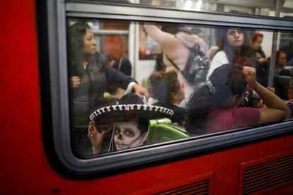 Un niño disfrazado de Catrín visto desde una de las ventanas del metro de Ciudad de México, la noche del 1 de noviembre de 2023. 