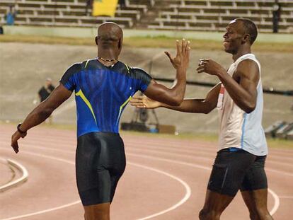 Asafa Powell, a la izquierda, saluda a Usain Bolt tras su enfrentamiento de junio en Jamaica.