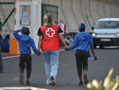Un efectivo de la Cruz Roja escolta a dos de los menores en puerto de La Estaca en El Hierro, el pasado septiembre.