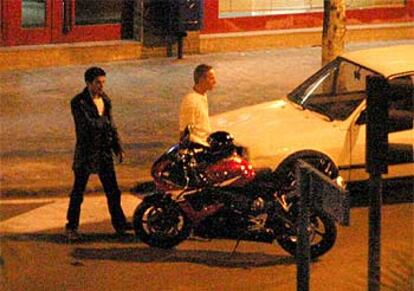 El atracador (izqda.), acompañado de un rehén cuando se disponía a comprobar la motocicleta que había solicitado para huir.