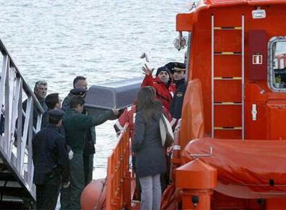 Miembros de los equipos de rescate trasladan a tierra el cuerpo de la joven que se ha ahogado tras un golpe de mar en A Coruña.