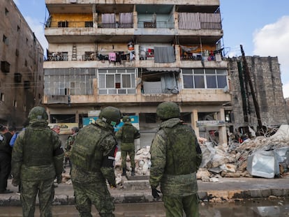 Soldados rusos frente a los escombros de los edificios derruidos en Alepo (Siria), el martes.