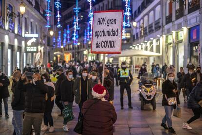 Un hombre sostiene un cartel con el lema "HOY, gran oportunidad de Covid!" en la calle del Carmen de Madrid. En cuanto a las residencias de ancianos, en la Comunidad de Madrid, se permite la salida de los usuarios por Navidad, aunque no tengan anticuerpos contra el coronavirus, pero en estos casos será por un mínimo de tres días, a un solo domicilio y deberán someterse a una prueba diagnóstica al regresar.