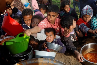 Niños palestinos esperan para recibir una ración de comida, en Jan Yunis, en el sur de Gaza, este lunes.