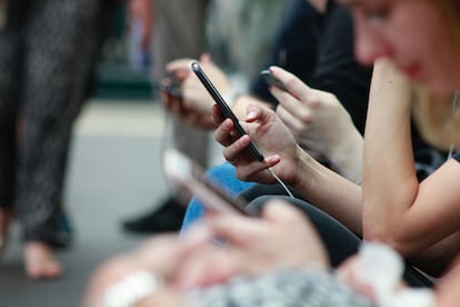 Adolescentes usando sus teléfonos móviles.