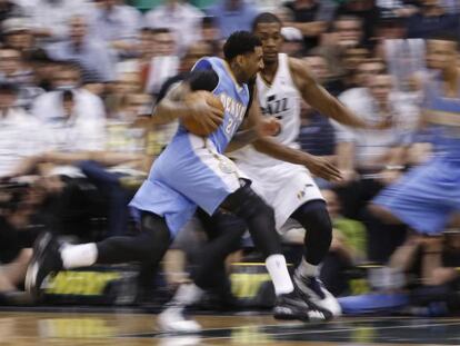 Wilson Chandler, de Denver, frente a Derrick Favors, de Utah.