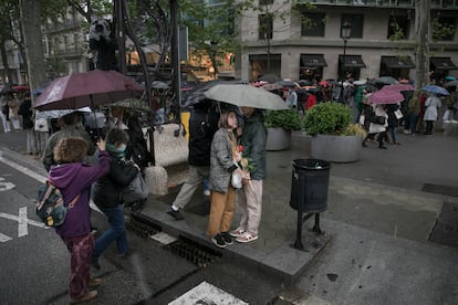 Una pareja se refugia de la fuerte granizada durante la Diada de Sant Jordi en Barcelona. 