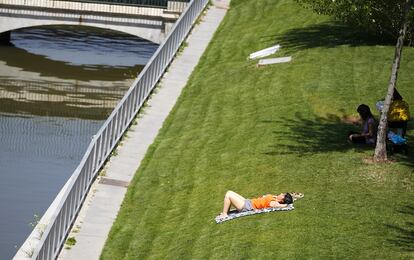 Este miércoles es el peor día del fenómeno, con temperaturas de más de 30 grados en casi todo el país y hasta 40 grados de máxima en la mitad sur de la península, donde se puede llegar incluso a 42. En la imagen, una mujer toma el sol en Madrid Río.