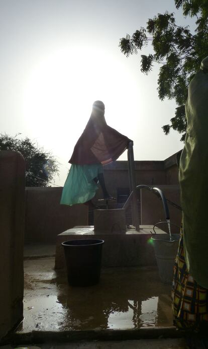 Una niña saca agua de una fuente en el distrito de Sona, Níger.