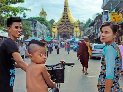 Una pareja y su hijo en una de las calles que dan paso a una de las entradas del complejo religioso de Shwedagon, uno de los centros budistas más importantes de la antigua capital de Myanmar.