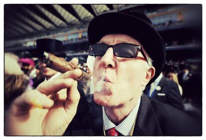 Un espectador fuma un puro en el primer día de carreras en el hipódromo de Ascot (Inglaterra), 17 de junio de 2014.