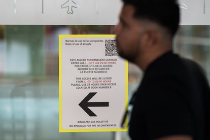 Un persona junto a un cartel de acceso cerrado, en la Terminal 4 del aeropuerto Adolfo Suárez Madrid-Barajas, este miércoles.