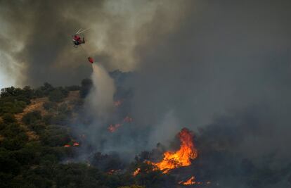 El Plan Infocam, en su perfil de la red social Twitter, ha indicado que el incendio de Toledo, que se declaró en la tarde de este viernes en el paraje conocido como Cerro de los Palos y que obligó al desalojo de una urbanización se mantiene en nivel 1. En la imagen, un helicóptero lazan agua sobre el incendio en las proximidades de Toledo capital, este viernes.