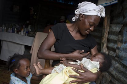 Masita Lemorin, una madre de 26 años, alimenta a su hijo Nathanael, de cuatro meses, mientras su hija Anne mira la escena en su casa en Quicroit, un pueblo aislado en las montañas al sur de Puerto Príncipe (Haití).