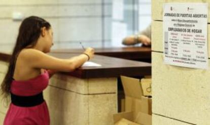 Una mujer registra a su empleada de hogar en una oficina de la Seguridad Social en Madrid el pasado junio.