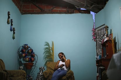 Los ocupantes ilegales han tenido que colocar ladrillos en los peligrosos espacios abiertos e instalar sus propios sistemas eléctricos y de agua. En la imagen, Thais Ruiz, de 36 años, habla por teléfono mientras bebe un café en su apartamento de la planta 27 de la "Torre de David".