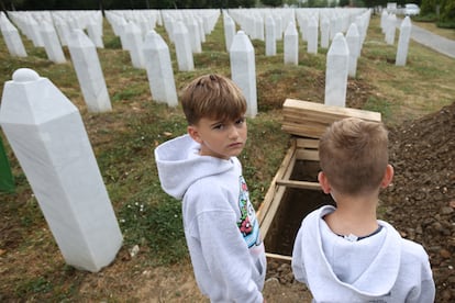 Varios niños bosnios observan las tumbas excavadas, en el Centro Conmemorativo de Srebrenica-Potocari, con motivo del funeral por las víctimas del genocidio de Srebrenica, este jueves en Protocari.