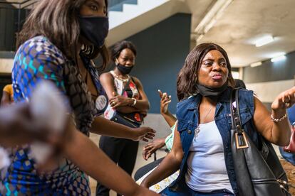 Un grupo de mujeres migrantes, casi todas sin mascarilla, aguarda para entrar en una sala donde realizarán un taller de empoderamiento femenino en Pretoria, Sudáfrica, en diciembre de 2020. Pincha en la imagen para ver la fotogalería completa.
