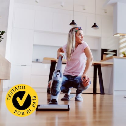 Una mujer con una fregona eléctrica en su casa.