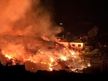 A lava do vulcão Cumbre Vieja avança sobre as casas da ilha espanhola de La Palma, nas Canárias, na noite de domingo.