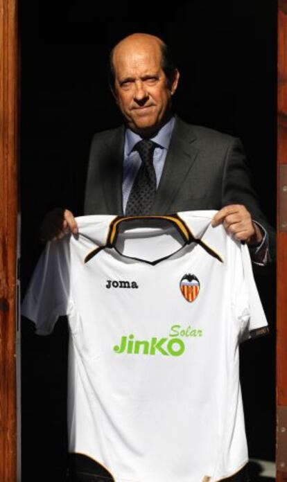 Manuel Llorente, presidente del Valencia, sostiene una camista del club