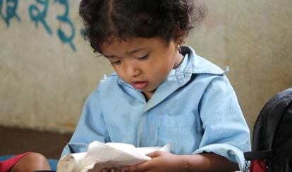 Una ni&ntilde;a lee en su cuaderno en una escuela rural de Nepal.