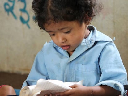 Una ni&ntilde;a lee en su cuaderno en una escuela rural de Nepal.