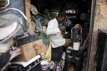 Un hombre repara un aparato eléctrico en su tienda, en el mercado central de Agadez.