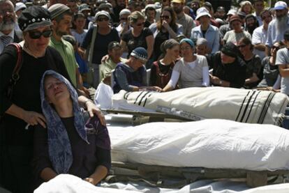 Los familiares de tres de los cuatro israelíes asesinados en un tiroteo, durante el funeral en Beit Hagai.