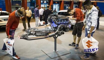 Varias personas observan un motor en el Salón del Automóvil de Madrid
