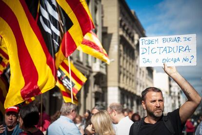 Un manifestante sostiene una pancarta que lee: 'Podemos hablar de dictadura ya, ¿o todavía no?'.