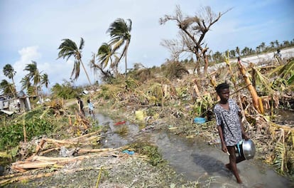 A girl walks amid the debris of crumbled buildings and damaged trees in the wake of Hurricane Matthew in Haiti.
