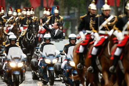 El flamante presidente francés, François Hollande, saluda desde su vehículo mientras desfila por los Campos Elíseos de París.