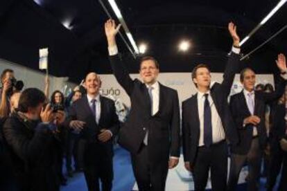 El presidente del PP y del Gobierno, Mariano Rajoy (c-izda), junto al candidato a la presidencia de la Xunta de Galicia, Alberto Núñez Feijoo (c-dcha), durante el mítin de cierre de campaña que ha tenido lugar en la Estacion Marítima de Vigo.