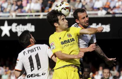 Piatti, Trigueros y Alcácer disputan un balón aéreo.