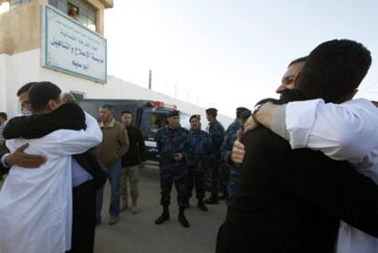 Dos presos del Grupo Islámico Combatiente Libio (vestidos de blanco) abrazan a familiares tras ser liberados ayer en Trípoli.